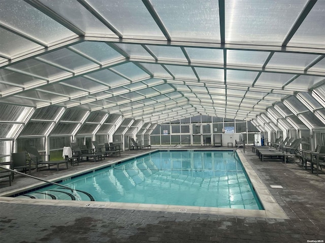 view of swimming pool with glass enclosure and a patio area