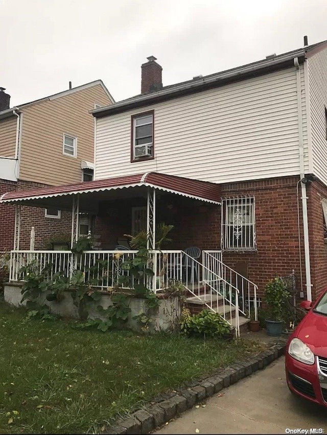 rear view of property featuring covered porch