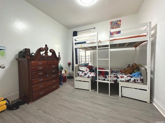 bedroom with light hardwood / wood-style flooring and lofted ceiling