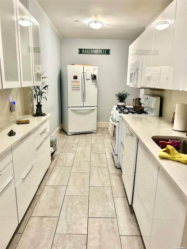 kitchen featuring white cabinets, white appliances, light tile patterned flooring, and sink