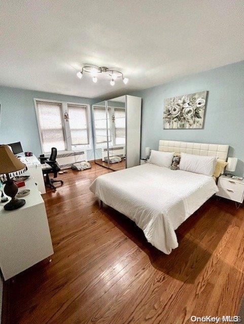 bedroom with dark hardwood / wood-style flooring and a textured ceiling