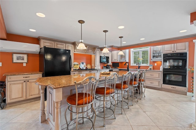 kitchen featuring a breakfast bar, light tile patterned floors, a kitchen island, light stone countertops, and black appliances