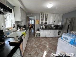 kitchen with white cabinets, extractor fan, and white appliances