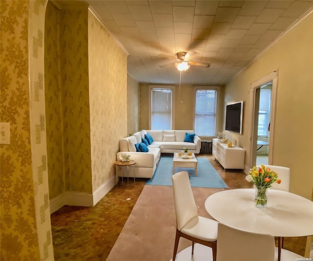 living room with ceiling fan and crown molding