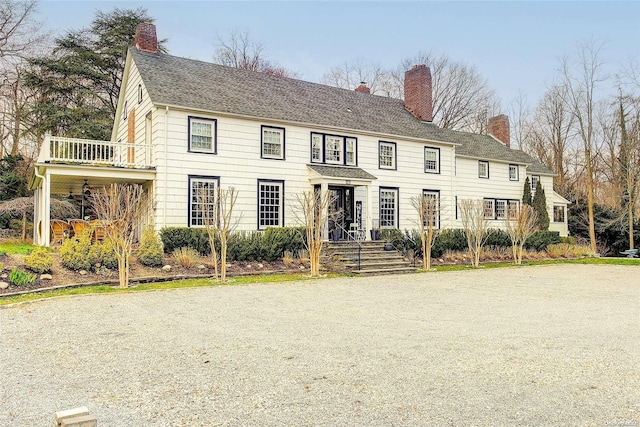 colonial house featuring a balcony and ceiling fan