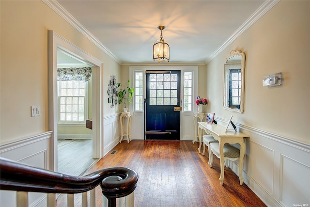 foyer featuring ornamental molding, an inviting chandelier, and dark wood-type flooring