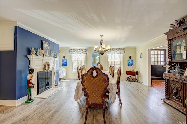 dining area featuring crown molding, a healthy amount of sunlight, and light wood-type flooring