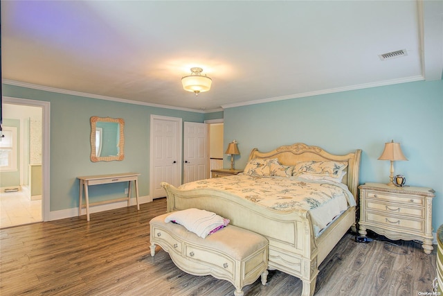 bedroom with hardwood / wood-style floors, connected bathroom, and crown molding