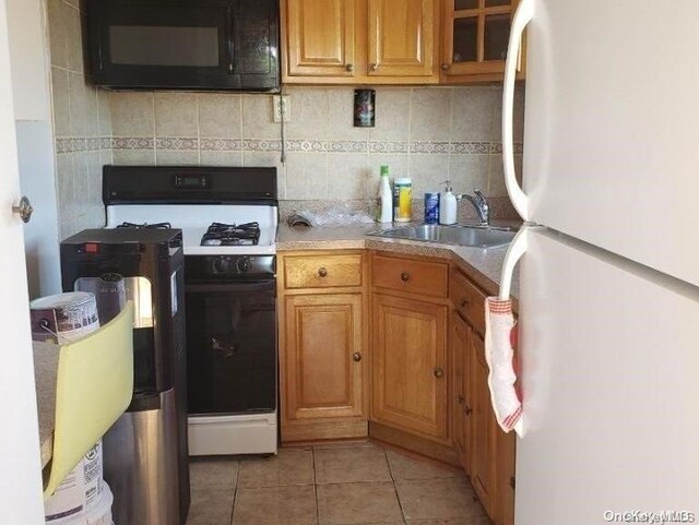 kitchen with tasteful backsplash, sink, light tile patterned floors, and white appliances