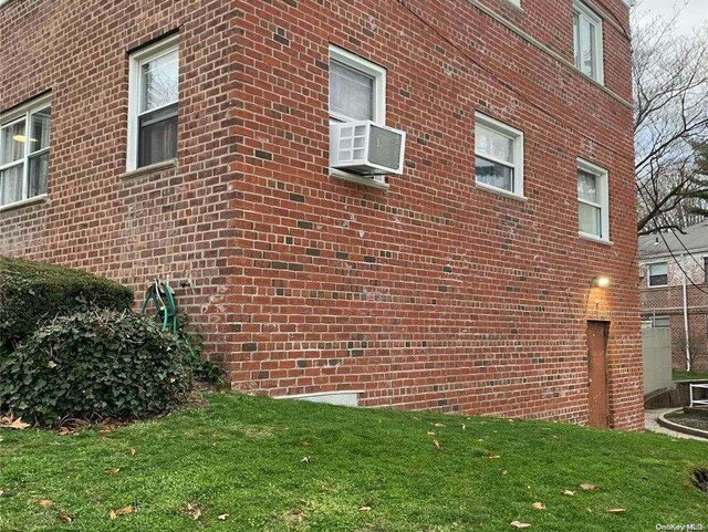 view of property exterior with a lawn and cooling unit