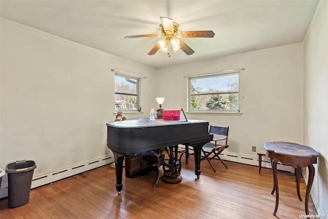 miscellaneous room featuring hardwood / wood-style flooring, ceiling fan, and a baseboard heating unit