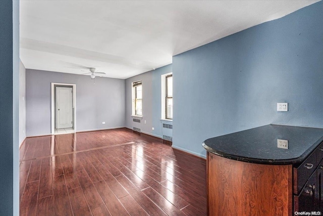 interior space with radiator heating unit, dark hardwood / wood-style flooring, and ceiling fan