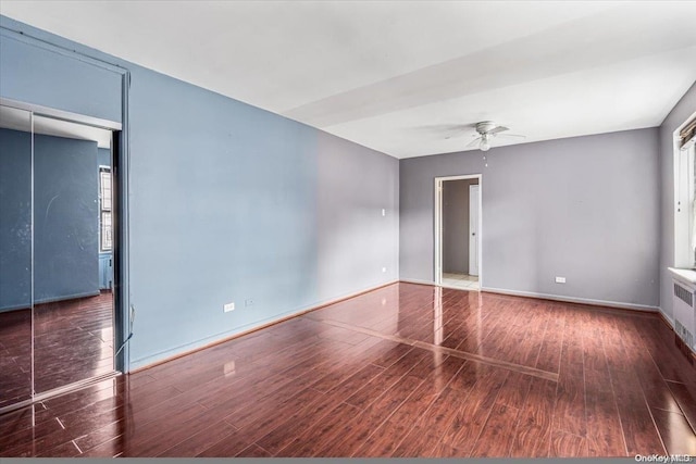 spare room featuring radiator, dark hardwood / wood-style flooring, and ceiling fan