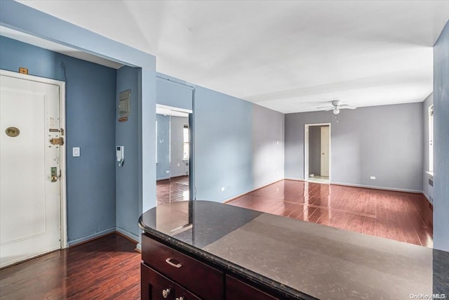 interior space featuring ceiling fan, plenty of natural light, and dark wood-type flooring