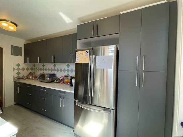 kitchen with decorative backsplash and stainless steel refrigerator