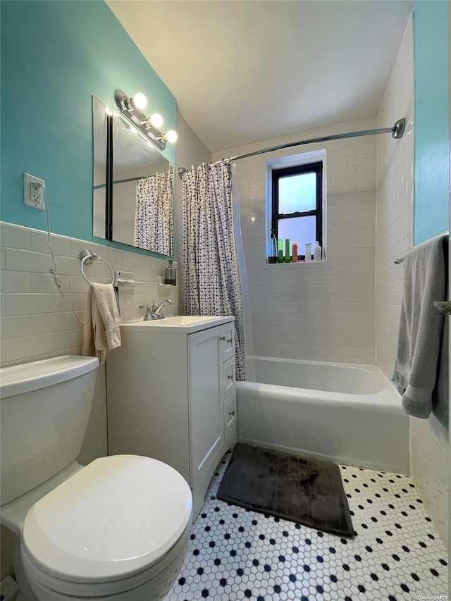 full bathroom featuring shower / bath combo, vanity, tile patterned floors, toilet, and tile walls