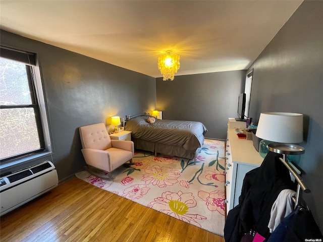 bedroom featuring wood-type flooring and a baseboard heating unit