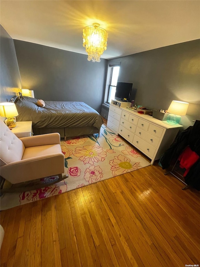 bedroom featuring hardwood / wood-style floors and a notable chandelier