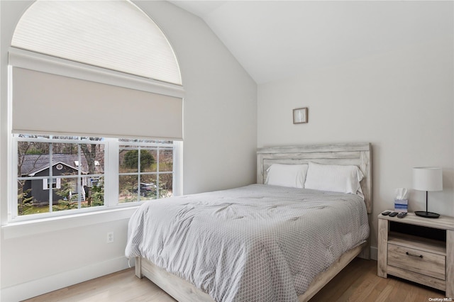 bedroom featuring light hardwood / wood-style floors and lofted ceiling