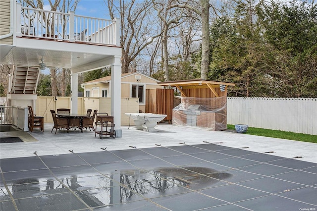 view of patio with ceiling fan and a balcony