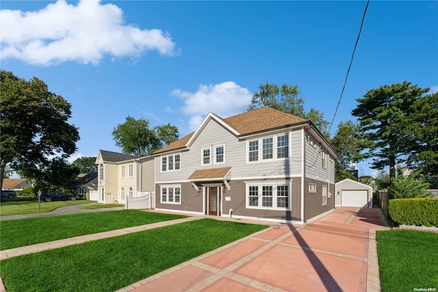 view of front of house with an outbuilding, a front lawn, and a garage