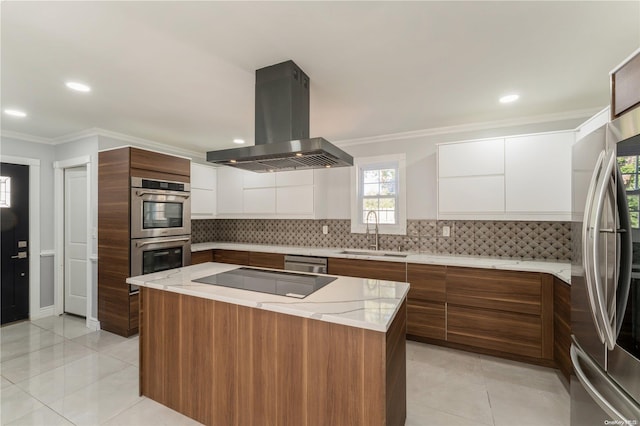 kitchen featuring appliances with stainless steel finishes, island range hood, sink, a center island, and white cabinetry