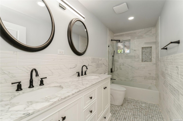 full bathroom with vanity, tiled shower / bath combo, tile walls, and toilet