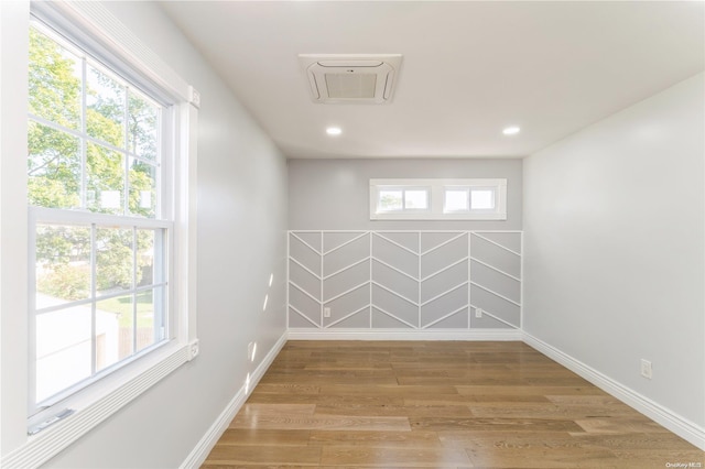 spare room with a healthy amount of sunlight and hardwood / wood-style flooring