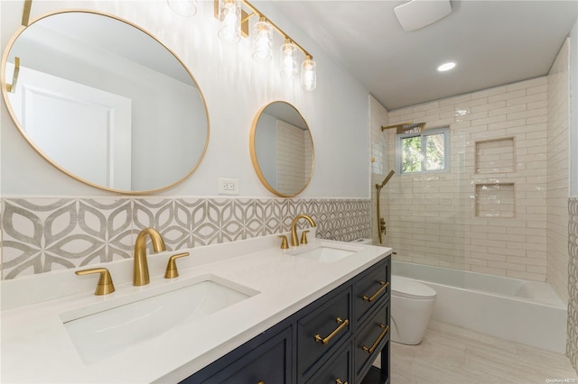 full bathroom featuring vanity, tiled shower / bath combo, tile walls, and toilet