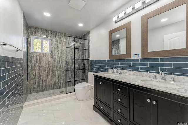 bathroom featuring vanity, toilet, a tile shower, and tile walls