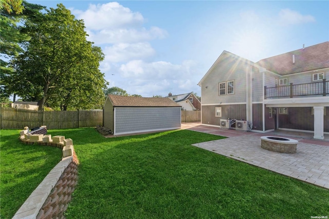 view of yard featuring a fire pit, a shed, and a patio