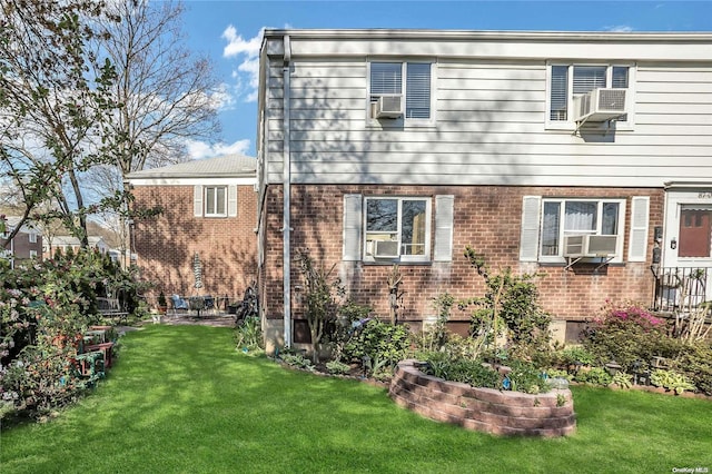 rear view of house with a yard and cooling unit