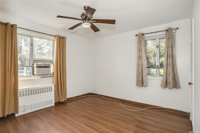 spare room featuring ceiling fan, dark hardwood / wood-style flooring, and radiator heating unit