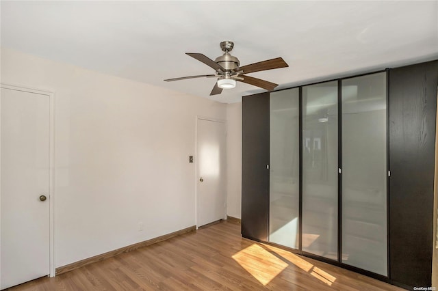 unfurnished bedroom with ceiling fan, light hardwood / wood-style floors, and a closet