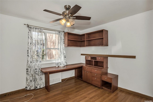 home office with ceiling fan and dark hardwood / wood-style flooring