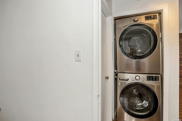 washroom with wood-type flooring and stacked washer and dryer