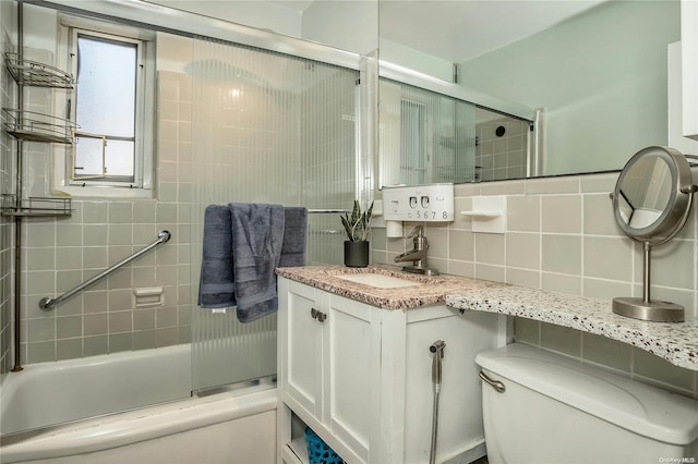 full bathroom featuring decorative backsplash, vanity, enclosed tub / shower combo, and toilet