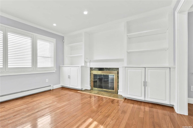 unfurnished living room with built in features, light wood-type flooring, a fireplace, and ornamental molding