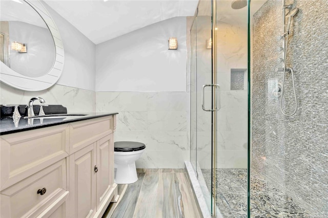 bathroom featuring hardwood / wood-style floors, vanity, toilet, tile walls, and a shower with shower door