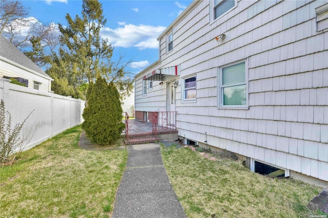 view of home's exterior with a deck and a lawn