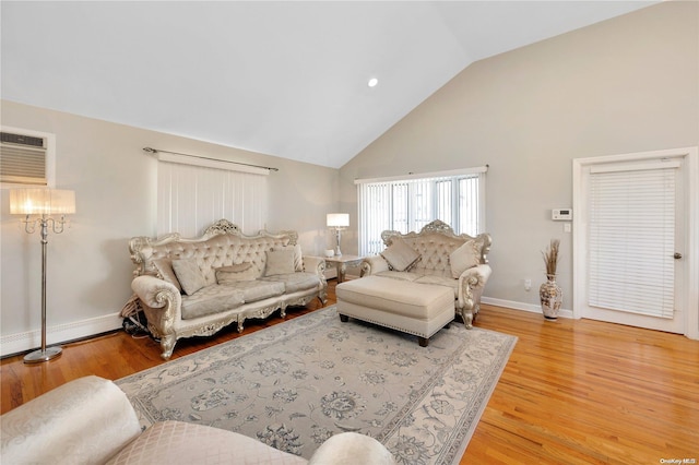 living room with hardwood / wood-style floors, a wall unit AC, and high vaulted ceiling