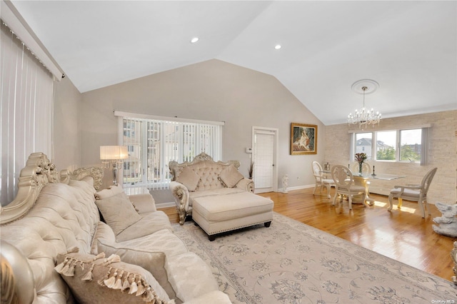 living room with light wood-type flooring, lofted ceiling, and a notable chandelier