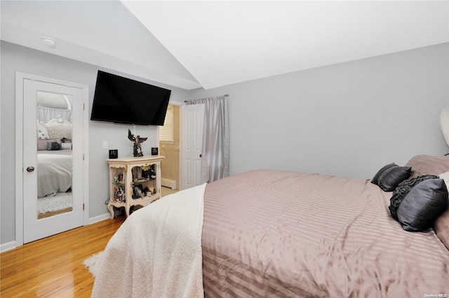 bedroom featuring light wood-type flooring and vaulted ceiling