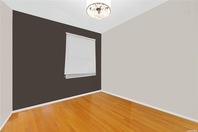 empty room with hardwood / wood-style floors and lofted ceiling