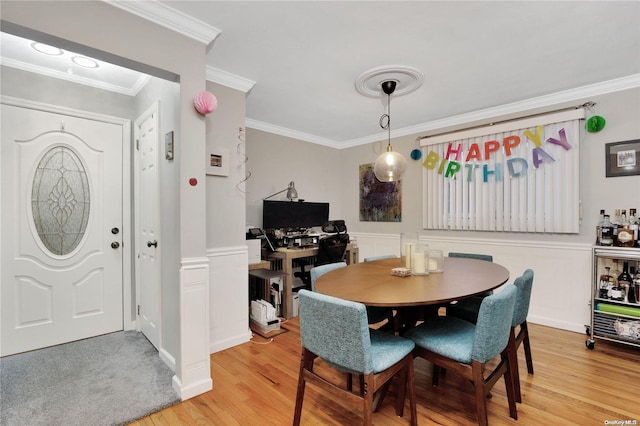 dining area featuring light hardwood / wood-style floors and crown molding