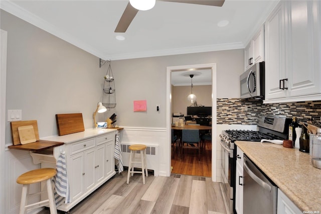 245 W Chester St W, Long Beach, NY 11561 - kitchen featuring appliances with stainless steel finishes, radiator, light wood-style flooring, a ceiling fan, and ornamental molding