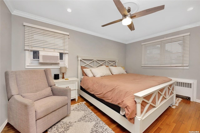 bedroom featuring radiator, cooling unit, ceiling fan, crown molding, and wood-type flooring