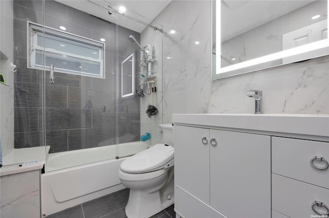 full bathroom with vanity, toilet, enclosed tub / shower combo, and tile walls