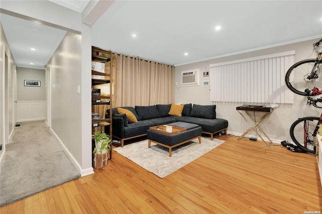 living room with a wall unit AC, crown molding, and light hardwood / wood-style floors