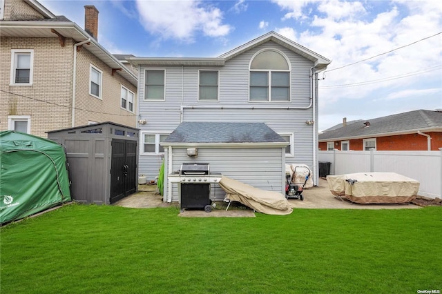 rear view of property featuring a lawn and a shed